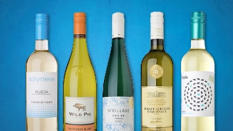 Verschillende flessen witte wijn van merken als Sol y Nieve, Wild Pig, Steillage, en anderen tegen een blauwe achtergrond.
