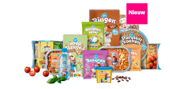 Assortiment van nieuwe Albert Heijn kinderproducten, inclusief soepstengels, rozijnen, pannenkoeken, pastasaus, water, snoepgroente, ontbijtgranen en appel, afgebeeld met verse tomaten en basilicum.