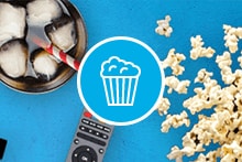 Filmscène met popcorn, drankje met ijsblokjes, afstandsbediening en filmklapper.