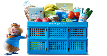 Blauwe Albert Heijn krat gevuld met verschillende producten zoals bananen, tomaten, komkommers, ontbijtgranen en crackers, met daarnaast de herkenbare AH hamster mascotte.