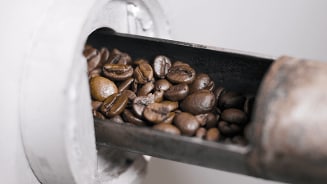 Koffiebonen in een metalen lade van een koffiemolen