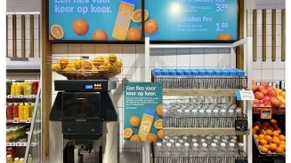 Promotiehoek in Albert Heijn met herbruikbare flessen en een sinaasappelpers.