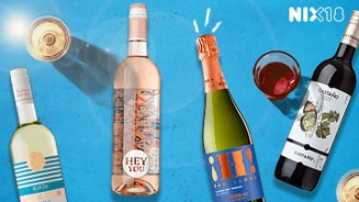 Verschillende flessen wijn en een fles mousserende wijn op een blauwe achtergrond, met gevulde wijnglazen. Tekst "NIX18" is zichtbaar rechtsboven, wat duidt op een campagne voor geen alcohol onder de 18 jaar.