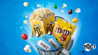 Bak popcorn, zakje M&M's Peanut, filmtickets en losse popcorn en M&M's op een blauwe achtergrond met Pathé-logo.