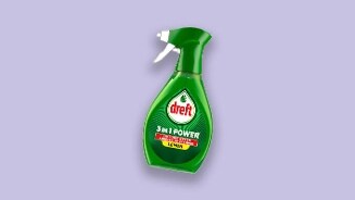 Groene fles Dreft 3 in 1 Power Lemon allesreiniger spray tegen vet op een paarse achtergrond.