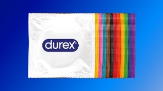 Durex condoomverpakking met kleurrijke regenboogstrepen op een blauwe achtergrond.