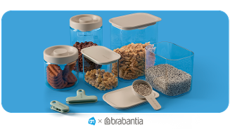 Voorraaddozen en vershoudclips van Brabantia, gevuld met koekjes, noten, pasta en zaden, op een blauwe achtergrond. Albert Heijn x Brabantia samenwerking.