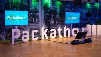 Packathon evenement met grote letters en schermen in een zaal van Albert Heijn