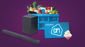 Albert Heijn boodschappenkrat gevuld met verse groente en producten, een AH cadeaukaart, een zwarte soundbar met subwoofer en een Supermarkt & Gemakswinkel van het Jaar 2024 award tegen een paarse achtergrond