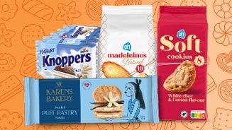 Afbeelding van verschillende koekjes en zoetwaren, waaronder Knoppers yoghurt, AH madeleines naturel, AH soft cookies met witte chocolade en citroensmaak, en Karens Bakery Danish puff pastry vanille, tentoongesteld op een oranje achtergrond met koekjespatroon.