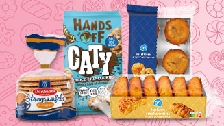 Verschillende zoete lekkernijen van Albert Heijn, waaronder Daelmans stroopwafels, Hands Off Oaty choco chip cookies, AH muffins en AH kokosmakronen, gepresenteerd tegen een roze achtergrond met illustraties.