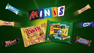 Assortiment van Mars minis chocoladerepen, waaronder Twix, Bounty, Mars, Snickers en Milky Way, verpakt in kleurrijke zakken tegen een groene achtergrond