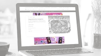 Laptop met Albert Heijn website met vegetarische recepten en Tony's Chocolonely promotie.