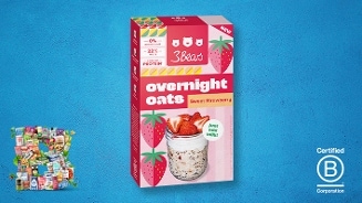 3Bears Overnight Oats Sweet Strawberry op een blauwe achtergrond met aardbeienillustraties op de verpakking, een potje overnight oats met verse aardbeien en een Certified B Corporation logo rechtsonder.