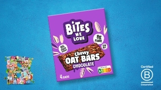 Bites We Love Chewy Oat Bars Chocolate verpakking op een blauwe achtergrond, met Nutri-Score A, B Corp certificering, en vermelding van 8 gram vezels, 0% toegevoegde suikers en 114 kcal per reep.
