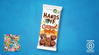 Reep Hands Off Caramel Sea Salt chocolade op een blauwe achtergrond, met een Certified B Corporation logo en diverse andere producten in miniatuur links onderin.