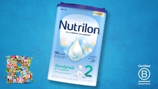 Grote verpakking Nutrilon 2 opvolgmelk voor baby’s van 6-10 maanden, op een blauwe achtergrond met Certified B Corporation logo.
