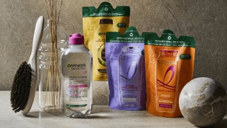 Haarverzorgingsproducten van Garnier en L'Oréal, waaronder een Garnier SkinActive Micellaire Reinigingswater en navulverpakkingen van L'Oréal, op een tafel.