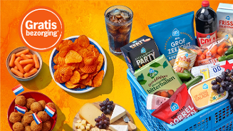 Assortiment van borrelhapjes, kaas, chips, frisdrank, groente snacks en een blauwe Albert Heijn winkelmand, met een sticker "Gratis bezorging" tegen een oranje achtergrond.