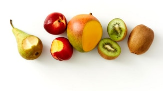 Verschillende soorten fruit, waaronder een peer, nectarine, mango en kiwi's, op een witte achtergrond.