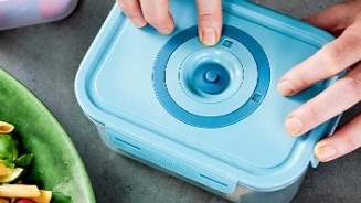 Persoon sluit een blauwe luchtdichte vershouddoos.