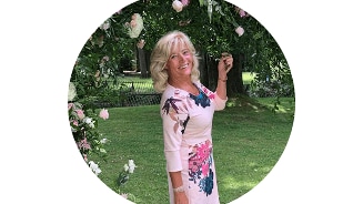 Vrouw in een gebloemde jurk in een tuinomgeving