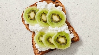 Eiwitrijke tussendoortje: volkoren brood met hüttenkäse en plakjes kiwi