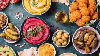 Assortiment van Mediterraanse gerechten zoals hummus, falafel, en olijven.
