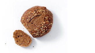 Volkorenbroodje met zaden en een sneetje ervan.