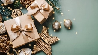 Kerstdcadeaus met gouden lint en kerstdecoratie zoals kerstballen, dennen takken en stervormige versiering op een groene ondergrond