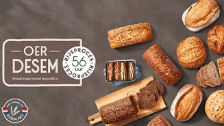 Oerdesem broodassortiment met verschillende broden, sneden brood en een boterhamtrommel op een bruine ondergrond. Tekst beschrijft 56 uur rijsproces en brood zoals brood bedoeld is.