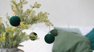 Groen witte kerstdecoratie met groene kerstballen aan een tak