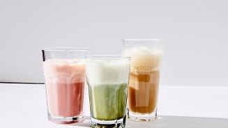 Drie glazen met plantaardige melk latte in verschillende kleuren