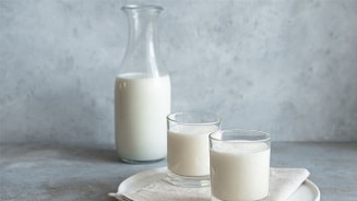 Fles en twee glazen melk op een dienblad.