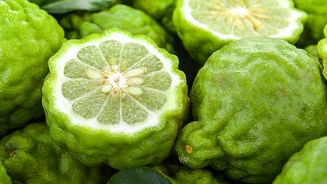 Bergamot citroenen met een doorgesneden vrucht, omringd door groene bladeren.
