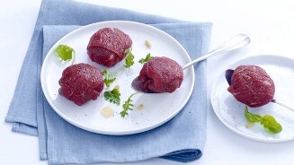 Bord met rundertartaar geserveerd met kruiden en Parmezaanse kaas.