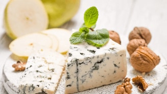 Gorgonzola met plakjes peer en walnoten op een bord