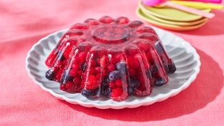 Jellypudding met rode vruchten op een wit bord