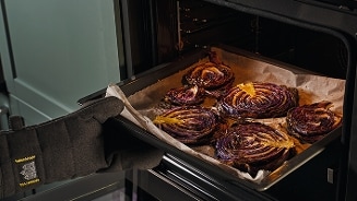 Geroosterde rode koolplakken in een oven op een bakplaat.