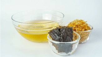 Dashi bouillon met kombu zeewier en katsuobushi schilfers in glazen kommen.