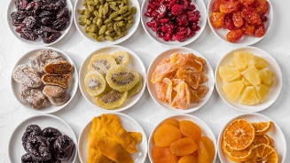 Een selectie van verschillende soorten gekonfijt fruit op witte schotels.