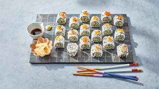 Sushiset op een zwart dienblad met sojasaus, wasabi, gember en eetstokjes