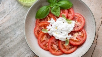Tomatensalade met mozzarella en basilicum in een kom.