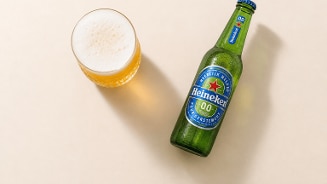Fles heineken 0.0 naast een glas met ingeschonken alcoholvrij bier.