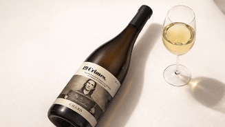 Fles 19 Crimes Chardonnay wijn met een gevuld glas witte wijn op een lichte ondergrond.