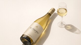 Fles El Maestro witte wijn met een gevuld wijnglas op een lichte ondergrond.