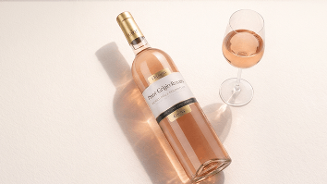 Fles Cantina Tamsa Pinot Grigio Rosato roséwijn naast een gevuld wijnglas, op een lichte ondergrond.