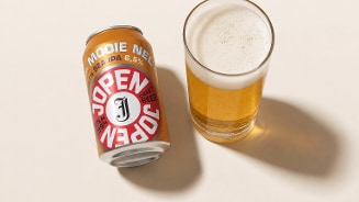 Blikje Mooie Nel van Jopen brouwerij met daarnaast een ingeschonken glas bier.