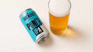 Blikje Punk IPA van Brewdog met daarnaast een ingeschonken glas bier.