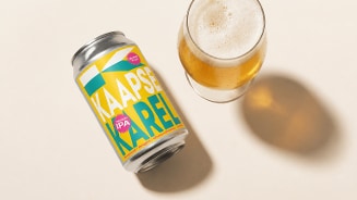 Blikje Kaapse Karel met daarnaast een ingeschonken glas bier.